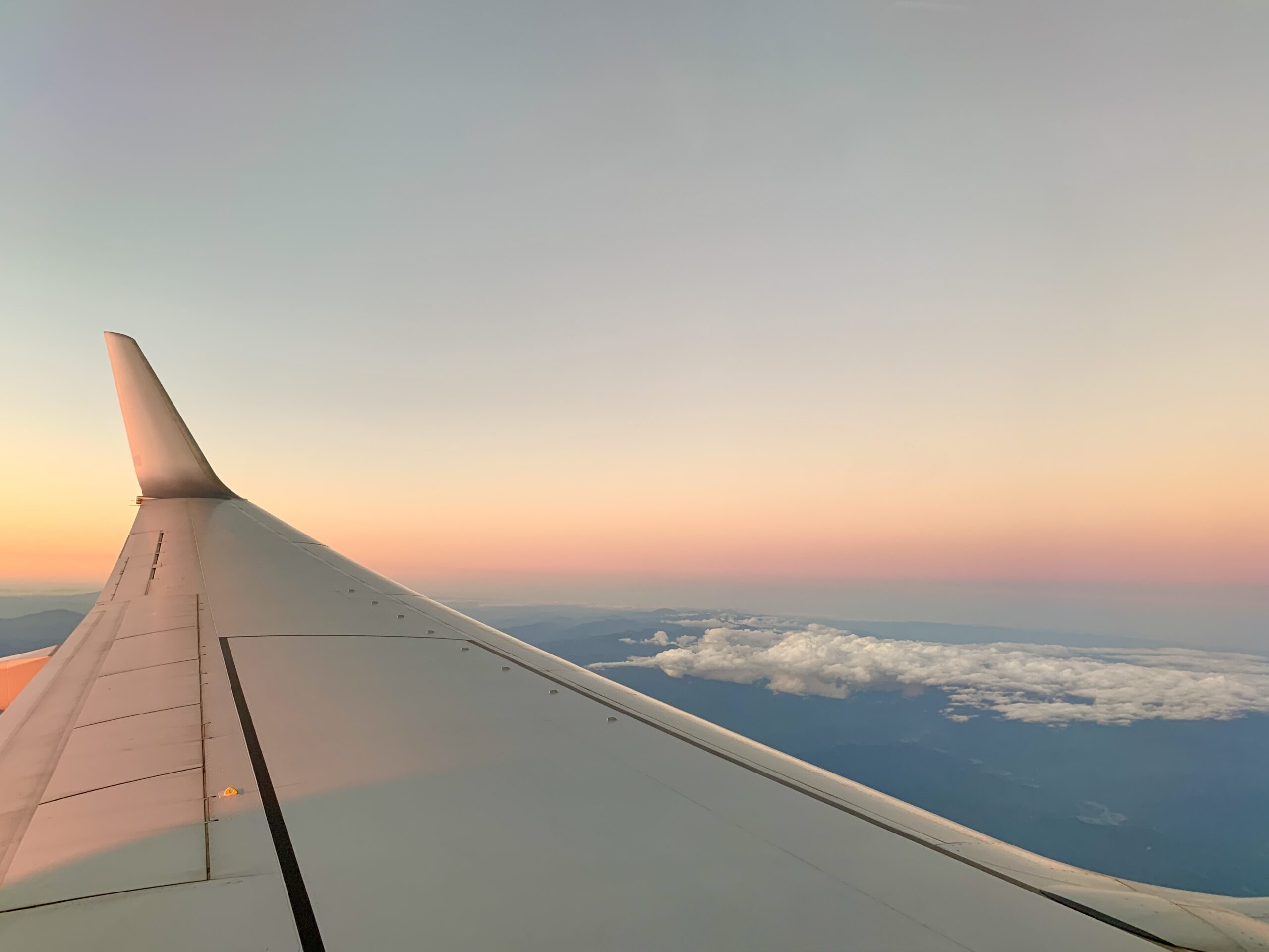 飛行機の窓から見える美しい夕日と翼
